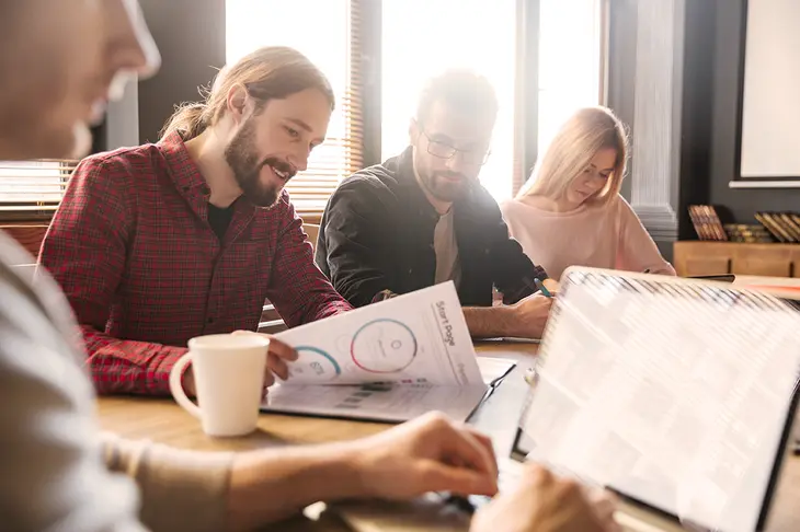 An image of a group of entrepreneurs huddled around a laptop, engaged in discussion and brainstorming, symbolizing the collaborative and dynamic nature of startup development