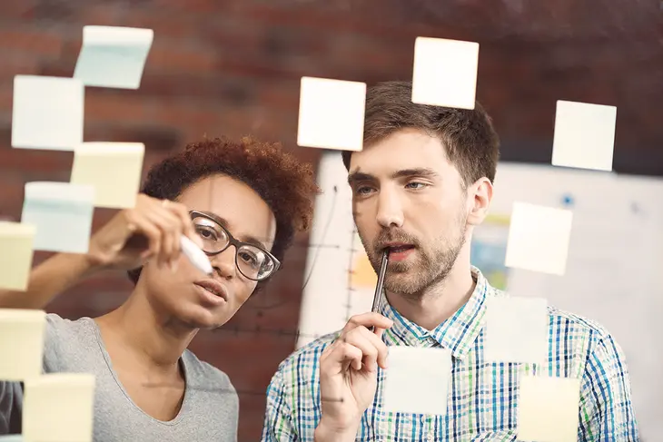 A diverse group of coworkers engaged in a meeting, actively listening to each other and exchanging ideas, illustrating the importance of open dialogue and respectful communication in the workplace.